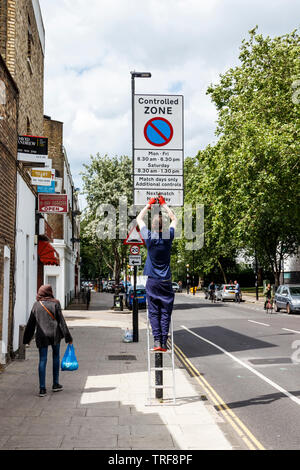 Ein RAT-Arbeiter bis al Addierer ändern ein Gleiches - Tag Parkplatz Einschränkung in Islington, London, UK Stockfoto