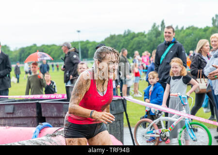 Warrington, Großbritannien. 2. Juni 2019. Rennen für das Leben 2019, Warrington, zugunsten der Krebsforschung. Läufer mit schlammigen Wasser an der Schlamm Grube getränkt Stockfoto