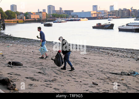 Zwei junge Menschen, Müll und Blick auf den Fluss Themse am Fluss Wasser bei Ebbe in Rotherhithe South London SE16 UK KATHY DEWITT Stockfoto