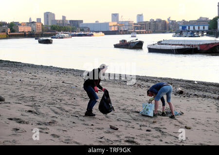 Zwei junge Menschen, Müll und Blick auf den Fluss Themse am Fluss Wasser bei Ebbe in Rotherhithe South London SE16 UK KATHY DEWITT Stockfoto