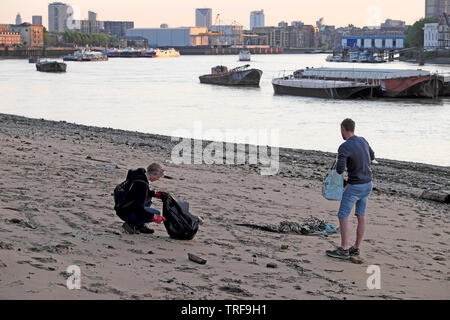 Zwei junge Menschen, Müll und Blick auf den Fluss Themse am Fluss Wasser bei Ebbe in Rotherhithe South London SE16 UK KATHY DEWITT Stockfoto