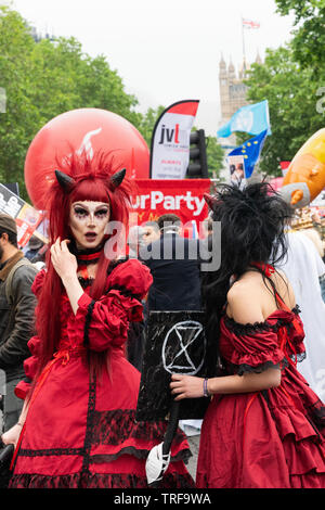 4. Juni 2019. London, Großbritannien. Anti Trump Rallye in Westminster. Eine Frau in Teufel Kostüm hält Aussterben Rebelion Plakat im Trump protestieren. Stockfoto