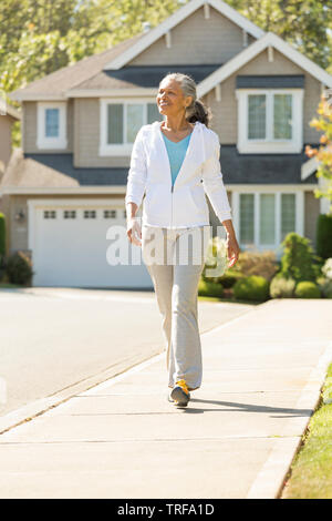 Glücklich, reife schwarze afrikanische amerikanische Frau zu Fuß in suburban Neighborhood. Aktiven, gesunden senior Lebensstile. Stockfoto