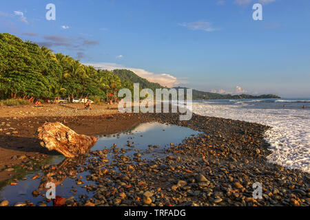 Ziel für Surfer, Playa Dominical in Costa Rica ist ein felsiger Strand meist durch ausländische Surfer abgerechnet. Stockfoto