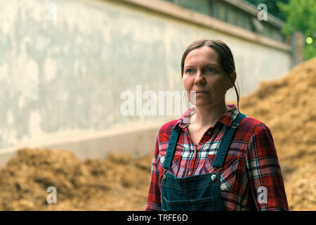 Frau Bauer vor der Pferdeäpfel Haufen auf die der Tierhaltungsbetrieb Stockfoto
