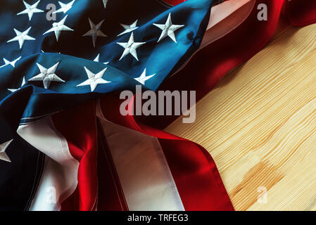 USA-Flagge auf hölzernen Hintergrund zerknittert, amerikanische Fahne mit gesticktem Sterne und Streifen Stockfoto