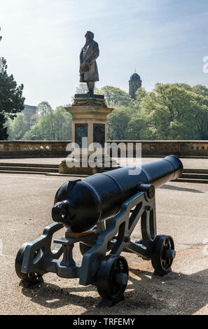 Einer der beiden Colonel William Dundas 68 pfünder Kanonen und der Gedenkstätte Statue von Sir Titus Salt iRoberts Park, Saltaire, Bradford, West Yorkshire Stockfoto