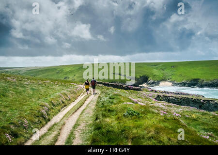 Menschen zu Fuß entlang des South West Coast Path auf wild zerklüfteten Küste bei Polly Porth Witz in Newquay in Cornwall. Stockfoto