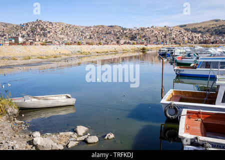 Touristische boote angedockt am Morgen Muelle Lacustre bei Puno am Titicacasee mit der Stadt Puno im Hintergrund, Puno, Peru Stockfoto