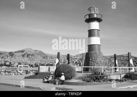 Die Frauen sitzen auf der Plaza del Faro oder Leuchtturm Platz an der Muelle Lacustre in Puno am Titicacasee, Puno, Peru in Schwarz und Weiß Stockfoto