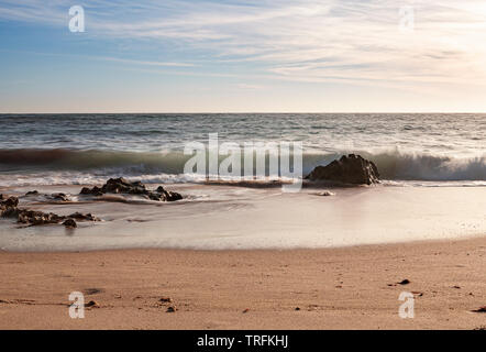 Felsen in der Brandung der Wellen am Strand. Stockfoto