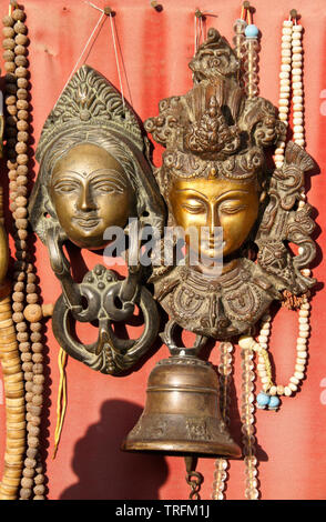 Buddhistische und Hinduistische Masken, Gebet, Perlen, und eine Glocke für Verkauf an Swayambhunath buddhistischen Tempel, Kathmandu, Nepal Stockfoto