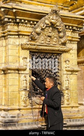 Tibetische Mann mit gebetsperlen verehrt, in einer Nische (mit Buddha Statue) des großen Stupa von Swayambhunath buddhistischen Tempel, Katmandu, Kathman Stockfoto