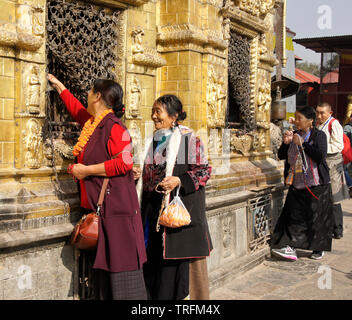 Der tibetischen Pilger in traditioneller Kleidung Anbetung an vergoldeten Nischen der großen buddhistischen Tempel Swayambhunath Stupa in Kathmandu Kathmandu Tal, N Stockfoto