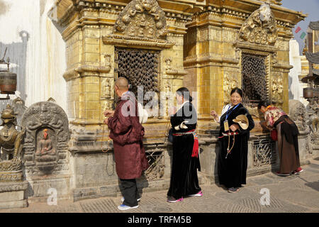 Der tibetischen Pilger in traditioneller Kleidung Anbetung an vergoldeten Nischen der großen buddhistischen Tempel Swayambhunath Stupa in Kathmandu Kathmandu Tal, N Stockfoto