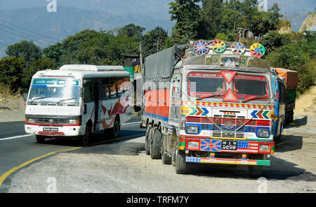 Kleiner Bus vorbei an bunt bemalte Tata cargo Truck auf der Kurve der ländlichen Tribhuvan Highway, Nepal geparkt Stockfoto