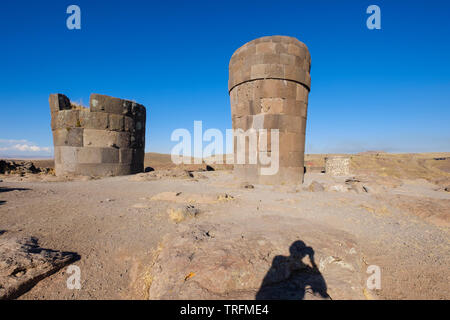 Schatten von einem Besucher Bilder aufnehmen auf einige der beeindruckenden präinkaischen Grabtürme von Sillustani chullpas genannt, Puno, Peru Stockfoto