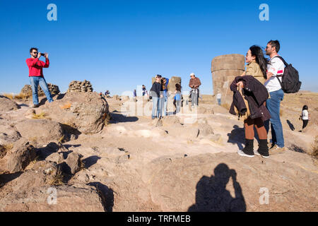 Gruppe von Touristen fotografieren und selfies mit einigen beeindruckenden präinkaischen Grabtürme von Sillustani chullpas genannt, Puno, Peru Stockfoto