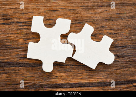 Puzzle auf hölzernen Hintergrund Top View/zwei puzzlestück Anschluss Business Solutions Erfolg und Strategie Konzept Stockfoto