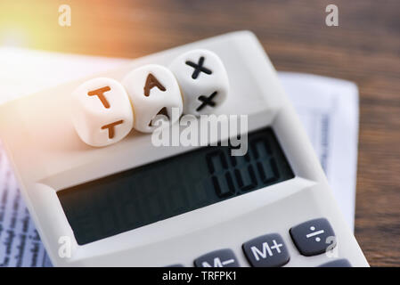 Die Worte, die er im Rechner auf Rechnung Rechnung Papier Finanzen für die Steuerberechnung Füllung bezahlt Schulden Zahlung am Tisch Office Business Stockfoto