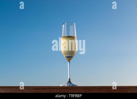 Ein Glas Champagner auf blauen Himmel Hintergrund isoliert. Stockfoto
