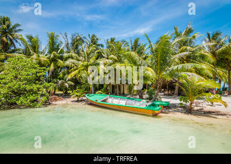 Schönen tropischen Destination mit Palmen und ein leeres Boot auf dem weißen Sandstrand der Insel Bora Bora, Französisch-polynesien angedockt. Stockfoto
