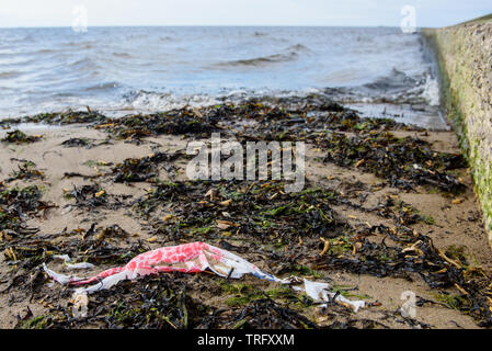 DAUGAVGRIVA, Lettland. 1. Juni 2019. Plastikbeutel liegend auf Sand am Strand in der Nähe von Ostsee. Stockfoto