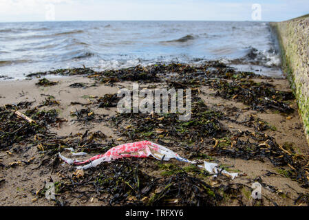 DAUGAVGRIVA, Lettland. 1. Juni 2019. Plastikbeutel liegend auf Sand am Strand in der Nähe von Ostsee. Stockfoto