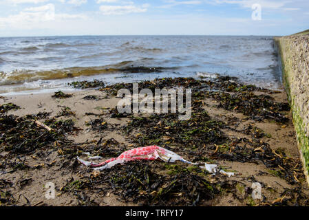 DAUGAVGRIVA, Lettland. 1. Juni 2019. Plastikbeutel liegend auf Sand am Strand in der Nähe von Ostsee. Stockfoto