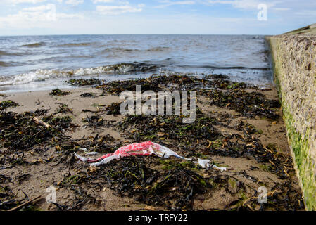 DAUGAVGRIVA, Lettland. 1. Juni 2019. Plastikbeutel liegend auf Sand am Strand in der Nähe von Ostsee. Stockfoto