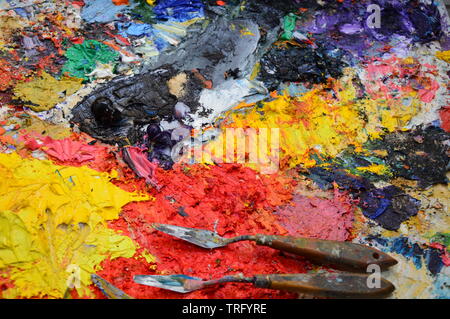 Zoom auf die Palette eines Malers in seiner Werkstatt mit Werkzeugen Stockfoto