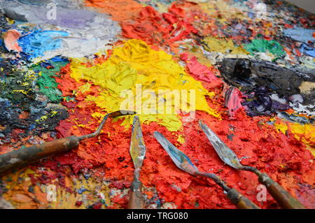 Zoom auf die Palette eines Malers in seiner Werkstatt mit Werkzeugen Stockfoto