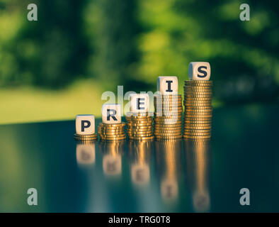 Symbol für steigende Preise. Würfel Form das deutsche Wort 'Preis' ('Preis' in englischer Sprache) auf steigenden hohen Stapel von Münzen. Stockfoto