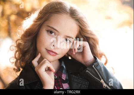 Schöne jugendlich Mädchen 12-14 Jahre alten legere stilvolle Kleidung posiert im Freien. Mit Blick auf die Kamera. Herbst Saison. Stockfoto