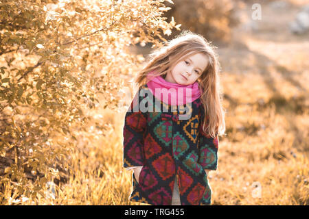 Stilvolle kind Mädchen 4-5 Jahre alten tragen Herbst Jacke im Park. Mit Blick auf die Kamera. Kindheit. Stockfoto