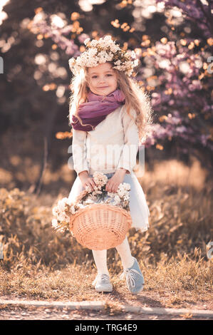 Glückliches Kind Mädchen 5-6 Jahre alten legere Kleidung im Freien. Holding Blumenkorb. Mit Blick auf die Kamera. Kindheit. Stockfoto