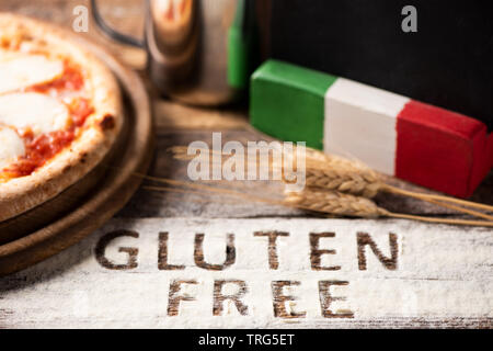 Eine glutenfreie Pizza auf eine rustikale Holz Hintergrund, in der Nähe Stockfoto