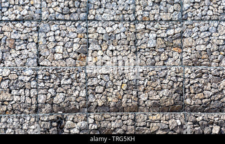 Steinmauer mit Metallgitter als Hintergrund. Stein -Textur Stockfoto