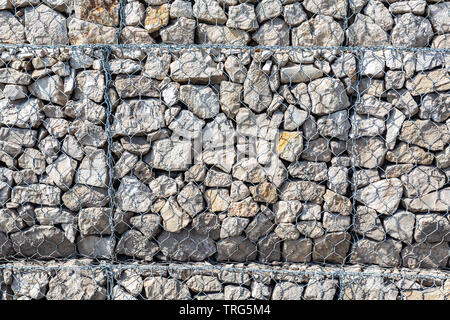 Steinmauer mit Metallgitter als Hintergrund. Stein -Textur Stockfoto