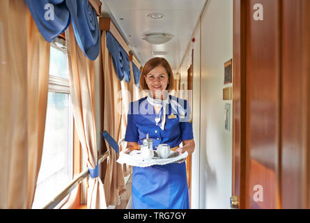 Zimmerservice im Luxus Trans-sibirischen Express 'Goldenen Adler'; Leiter, der sich in einem Luxus Auto; Russische Bahn; Luxus Zug; berufliche Tätigkeit Stockfoto