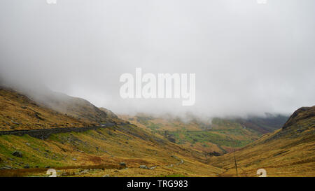 Atemberaubende Landschaft mit Nebel und Moody skies inmitten der Berge, bedeckt mit schönen Schnee - während einer Wanderung am Snowdon im Winter (Snowdoni erfasst Stockfoto