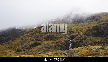 Atemberaubende Landschaft mit Nebel und Moody skies unter den Bergen und Bächen - während einer Wanderung am Snowdon im Winter (Snowdonia Nation erfasst Stockfoto