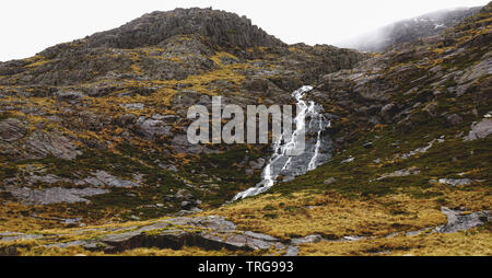 Atemberaubende Landschaft mit Nebel und Moody skies unter den Bergen und Bächen - während einer Wanderung am Snowdon im Winter (Snowdonia Nation erfasst Stockfoto