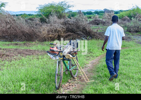 In einem Gebiet von Malawi durch Überschwemmung nach einem Mann Zyklon betroffenen trägt Paare verwendet, um Schuhe für den Verkauf auf seinem Fahrrad Stockfoto