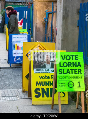 Man Walking Vergangenheit Lorne Grundschule Polling am Leith Walk Rat By-Election, Edinburgh, Schottland, Großbritannien mit parteipolitischen Boards Stockfoto