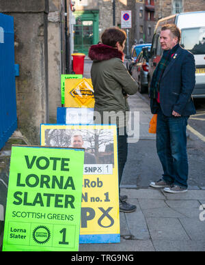 Man Walking Vergangenheit Lorne Grundschule Polling am Leith Walk Rat By-Election, Edinburgh, Schottland, Großbritannien mit parteipolitischen Boards Stockfoto