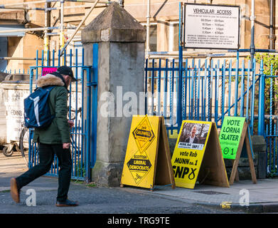 Man Walking Vergangenheit Lorne Grundschule Polling am Leith Walk Rat By-Election, Edinburgh, Schottland, Großbritannien mit parteipolitischen Boards Stockfoto