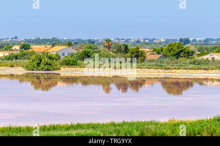 Siedlung rund um eine rosa Salz Verdunstung Teich in der Camargue in Südfrankreich Stockfoto