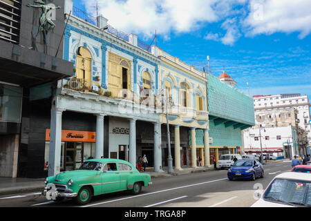 Havanna, Kuba - 30. Januar 2018: Buntes Haus vorne mit einem grünen klassisches, amerikanisches Auto vorne Stockfoto