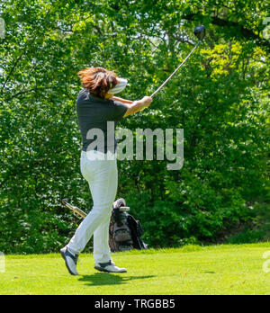 Braunschweig, Deutschland, 18. Mai 2019: Frau mittleren Alters schlagen den Ball über das Grün am Golfturnier des Deutschen Golf Verbandes Stockfoto